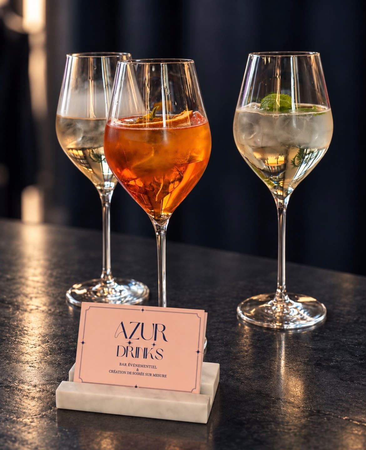 Trois cocktails et la carte de visite Azur Drinks