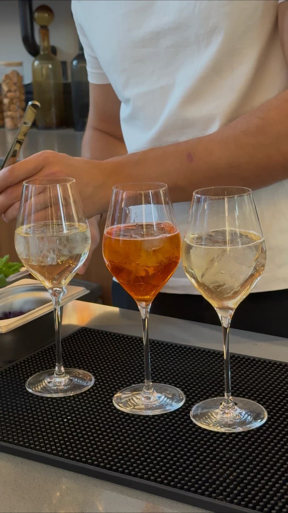 Trois spritz alignés sur le tapis de bar