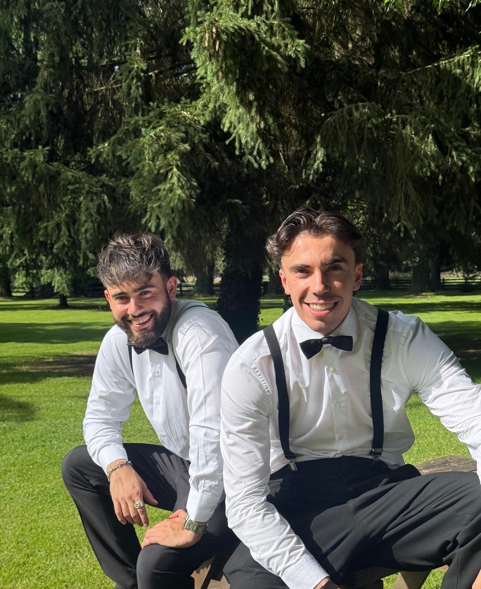 Les deux fondateurs d'Azur Drinks en chemise blanche et nœud papillon, assis dans un parc